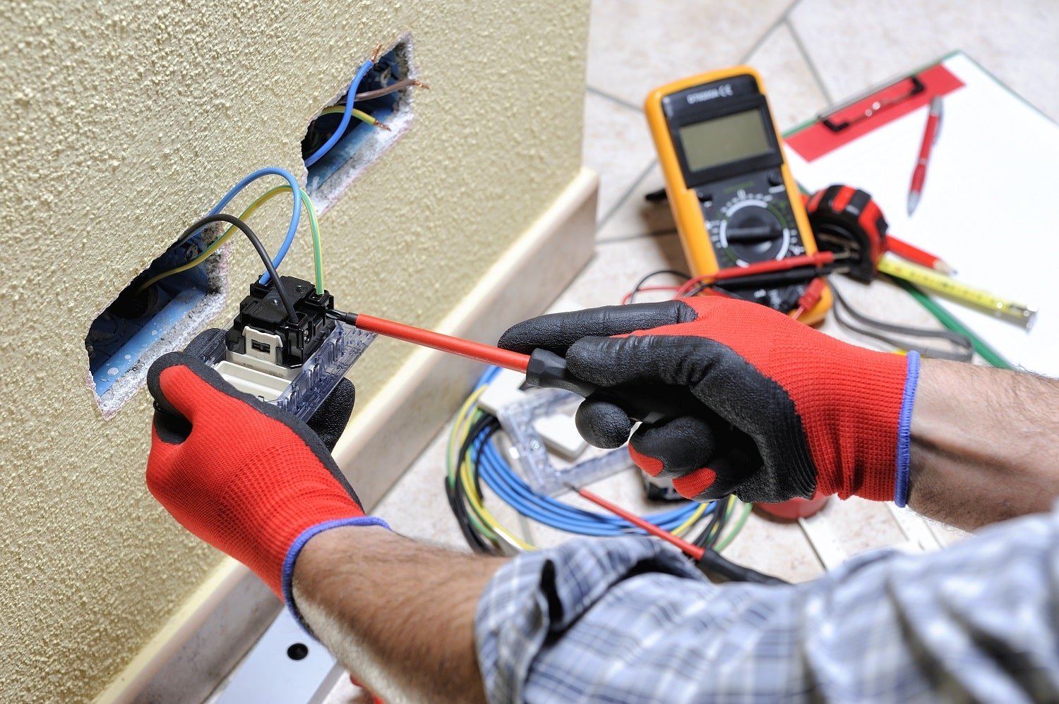 electrician technician at work with safety equipment on a residential electrical system